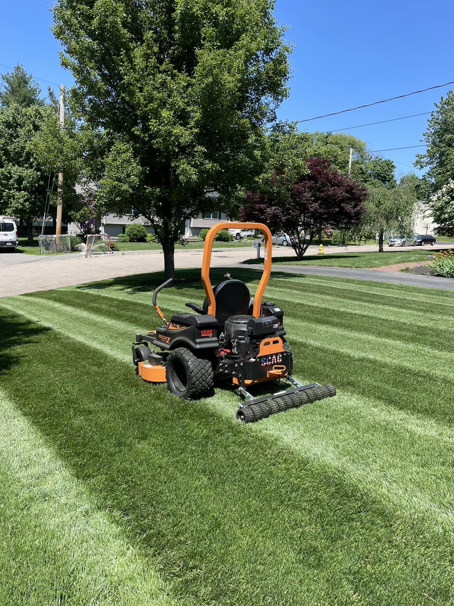 Zero-turn mower with a CheckMate lawn striper installed on a striped lawn