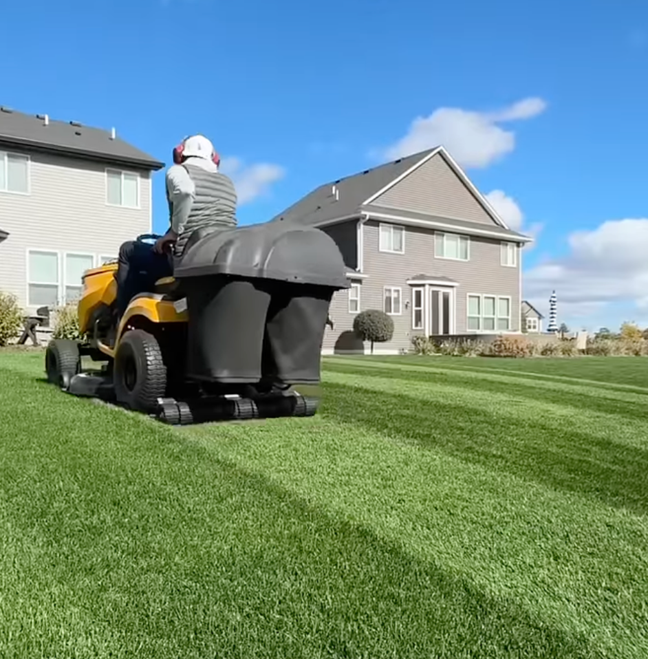 Lawn tractor mowing a striped lawn with a CheckMate striper installed